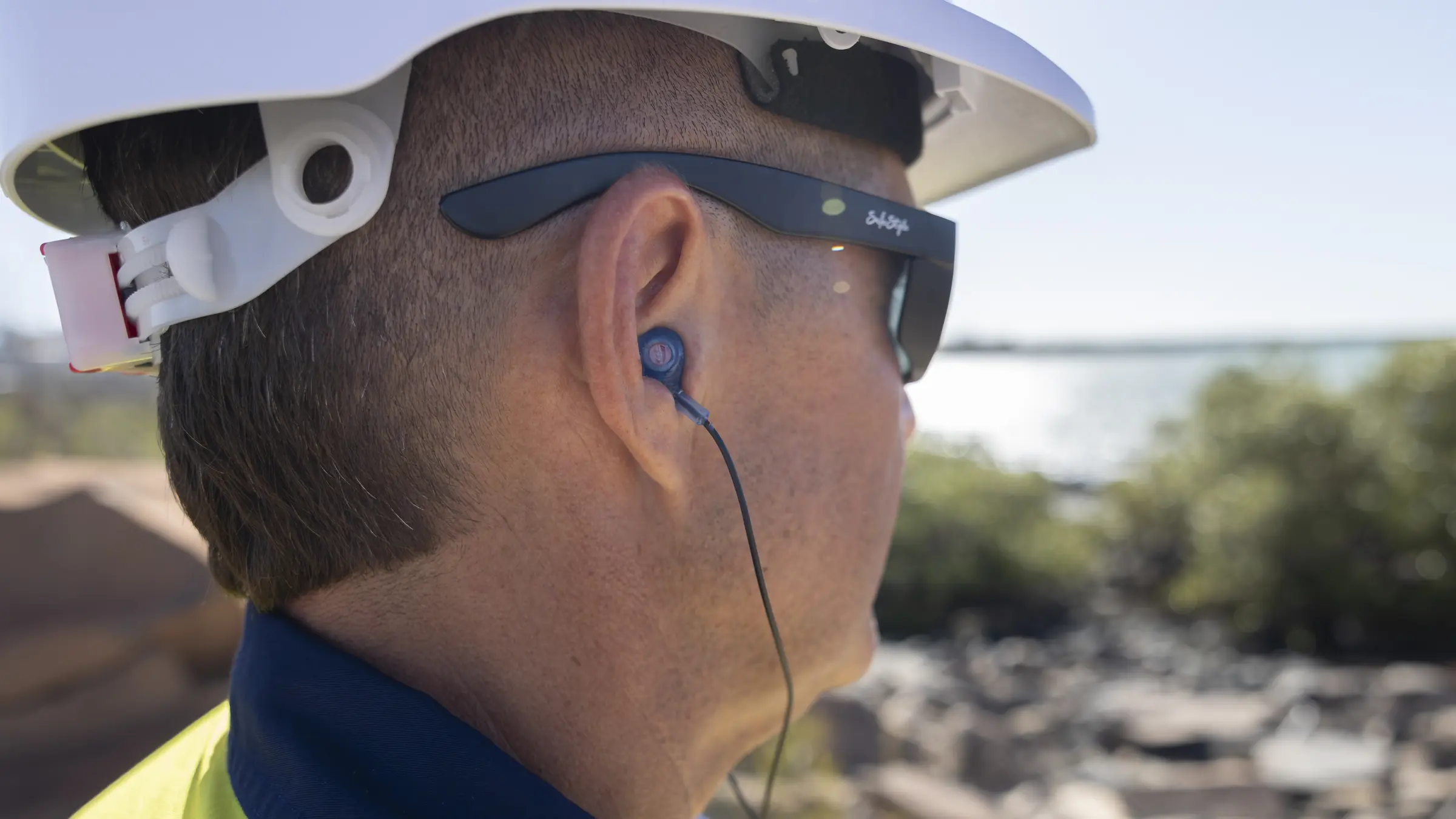 Worker wearing custom in-ear hearing protection viewed over the shoulder
