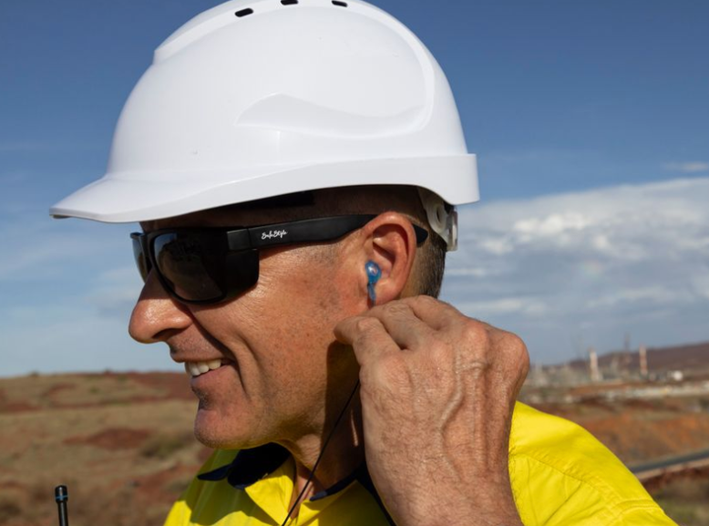 Worker wearing custom blue hearing protection